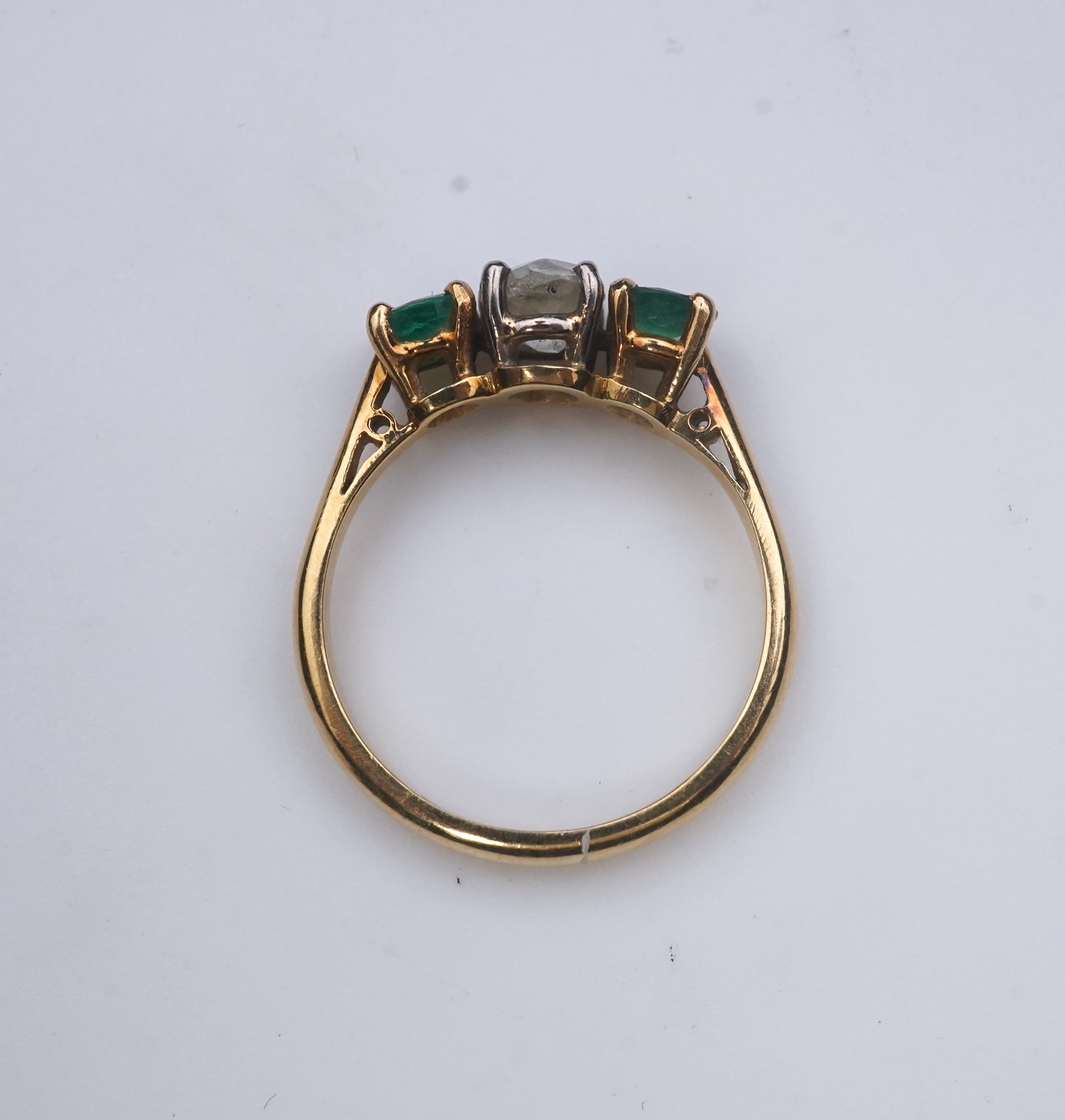 An emerald and diamond three-stone ring